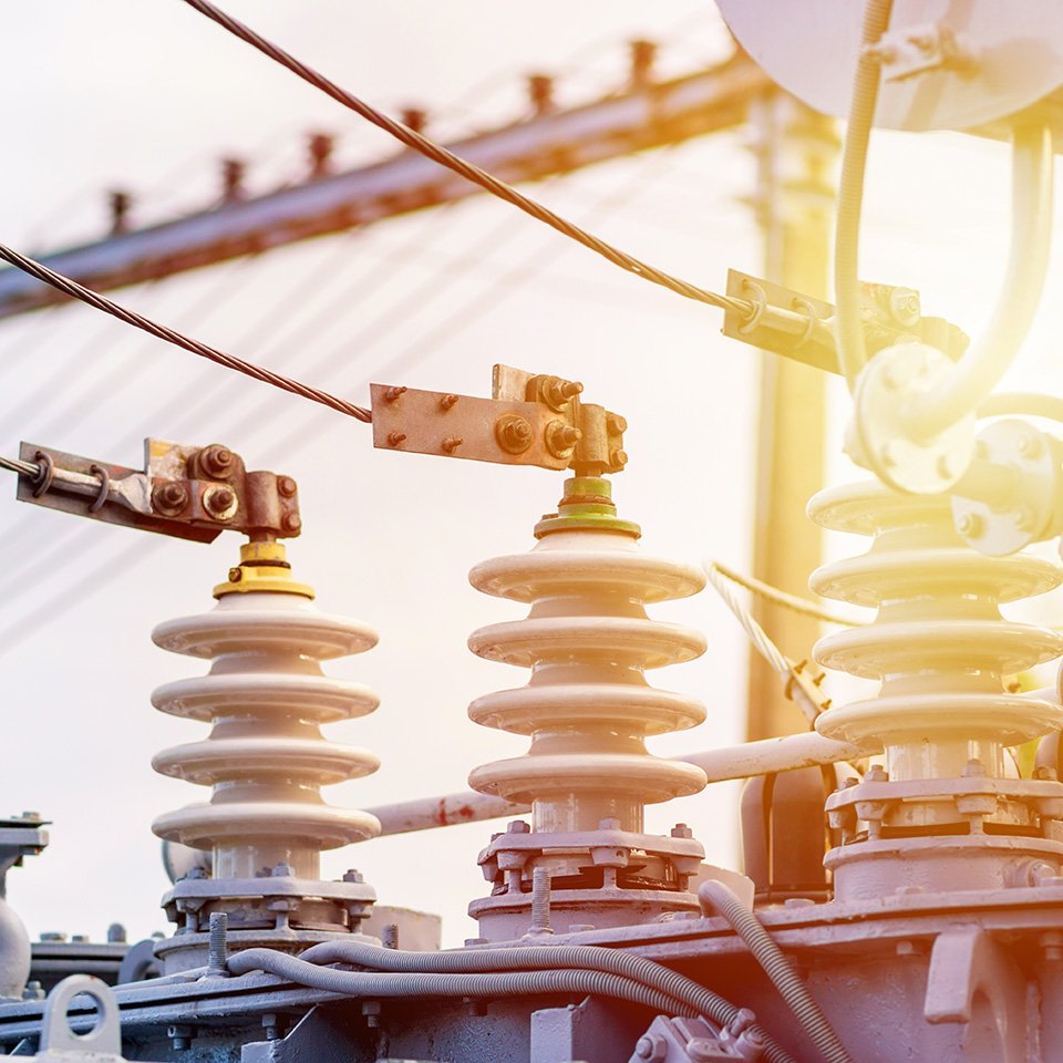 High‑voltage electrical insulators and connectors in a transformer setup, representing reliable transformer supply, installation, and maintenance services through NK Group’s trusted partner QTC.